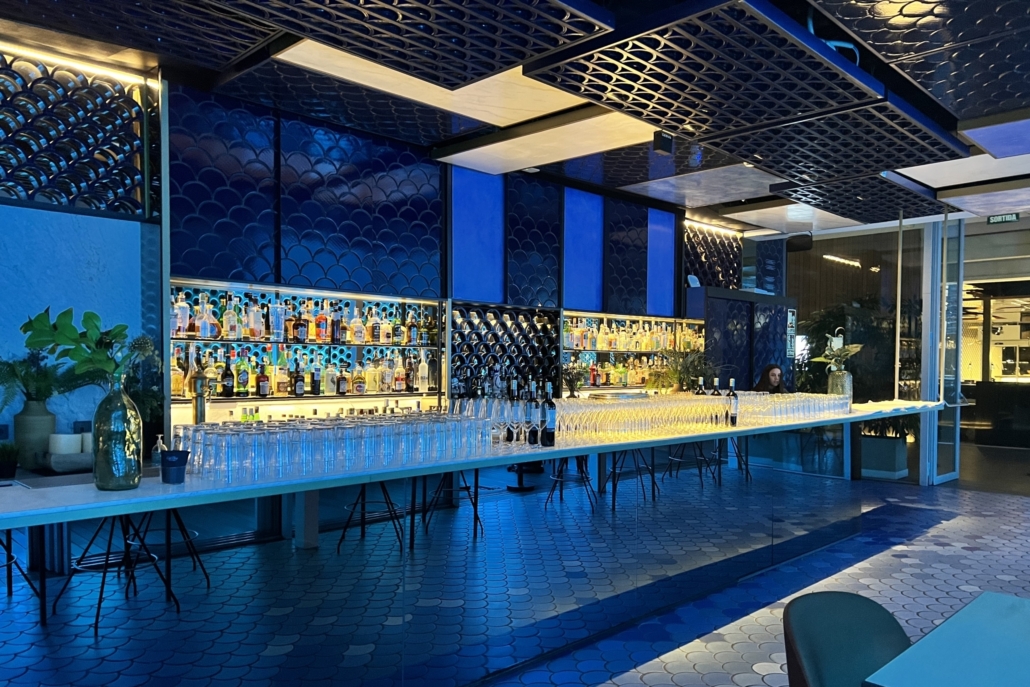 Salón azul con barra iluminada en el evento de VidaCaixa.